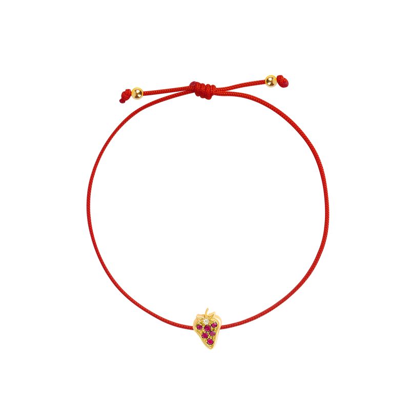 An adjustable red cord bracelet featuring a small yellow gold strawberry charm embellished with red gemstones, displayed on a clean white background.