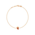 A delicate rose gold chain bracelet with a small strawberry shaped charm set with red stones, displayed on a clean white background.