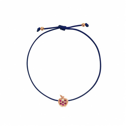 Rosmundo collaboration 18k rose gold apple string bracelet with natural rubies and diamond on adjustable macrame cord. A navy blue cord bracelet with a small rose gold apple charm set with purple gemstones, shown on a plain white background.
