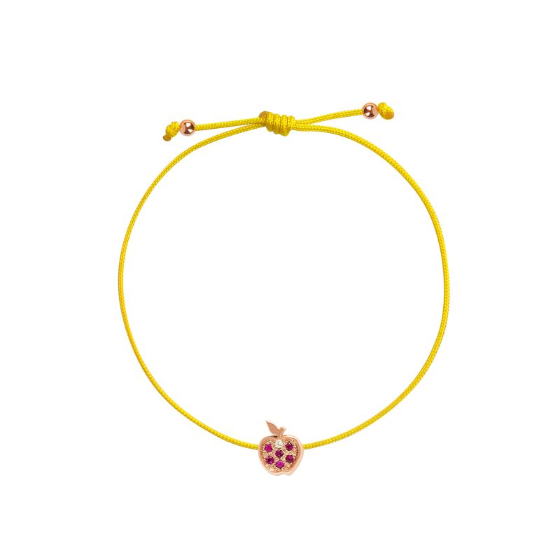 A yellow adjustable cord bracelet featuring a small rose gold charm shaped like an apple with purple gemstone accents, set against a plain white background.