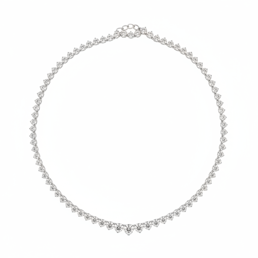 A delicate graduated, three prong  tennis necklace in white gold with small round dimonds, arranged in a circle on a plain white background.