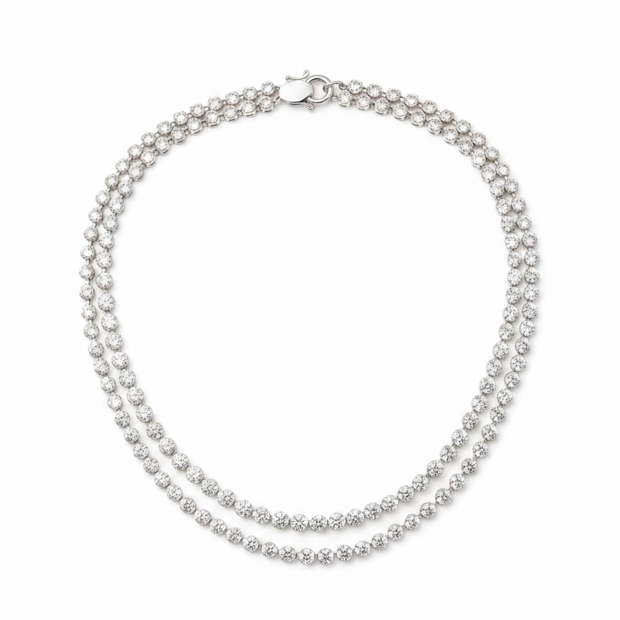 A double-strand tennis necklace featuring clear round-cut stones in a white gold setting, displayed on a clean white background.