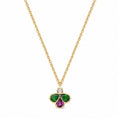 A gold chain necklace with a clover-shaped pendant featuring a small round diamond at the top, a green teardrop-shaped stones on the left and right, and a purple teardrop-shaped stone in the middle, set against a plain white background.