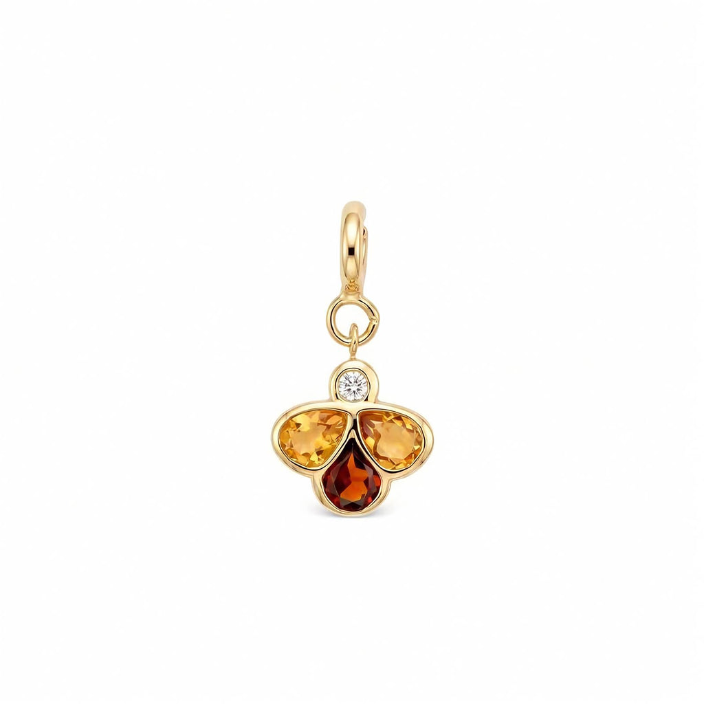 A gold charm pendant featuring three teardrop-shaped gemstones in yellow, orange, and amber-brown hues, with a small clear round-cut diamond at the top, set against a plain white background.