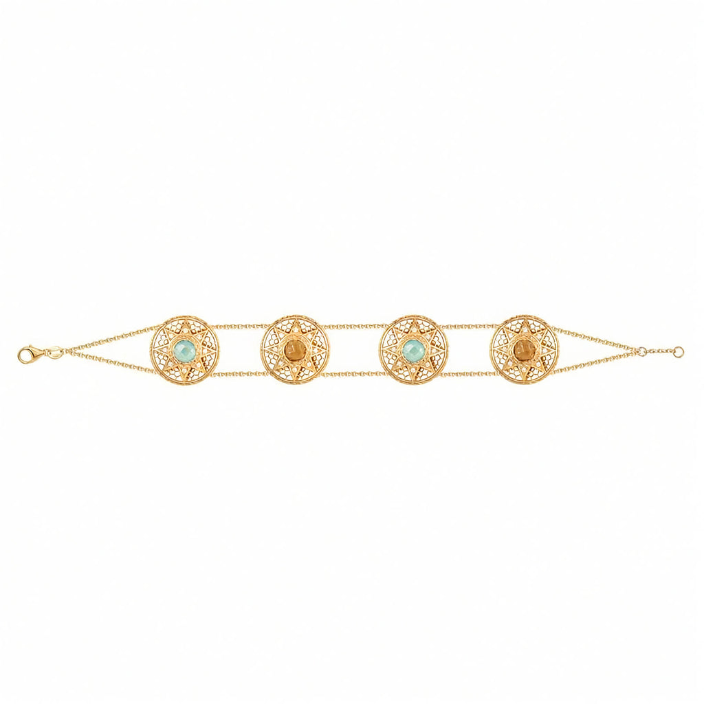 A gold chain bracelet featuring four ornate circular filigree medallions, each set with a light blue or yellow stone and a central gold bead, displayed on a clean white background.