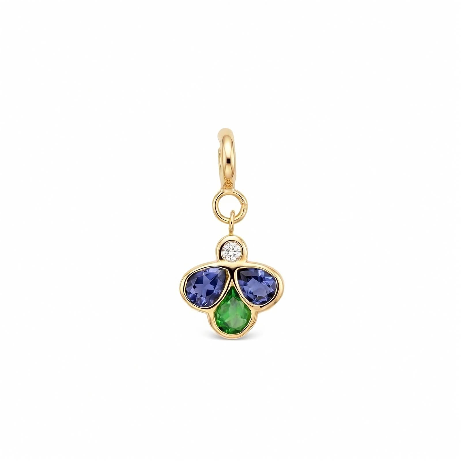 A yellow gold charm pendant featuring three flower-like stones in blue, green gemstones with a small clear round diamond above them, set against a plain white background.