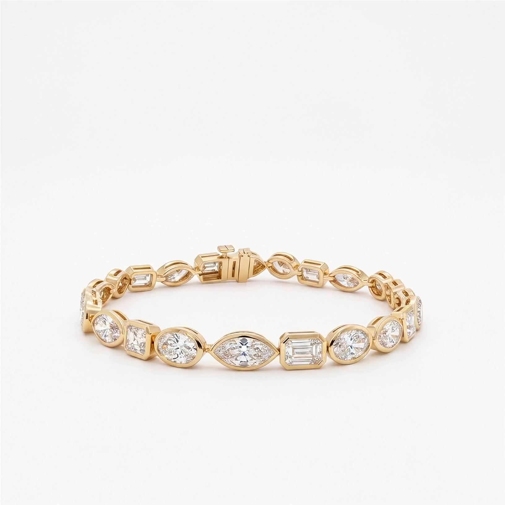 10.25 ctw mixed shape bezel set lab diamond tennis bracelet in 14k yellow gold with oval, marquise, and emerald cut diamonds on light gray background. 
