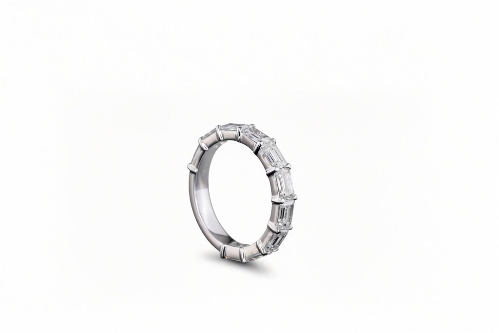 A white gold band ring featuring a row of lab grown emerald-cut diamonds, shown from a side profile on a clean white background. 3/4 all way around the band.