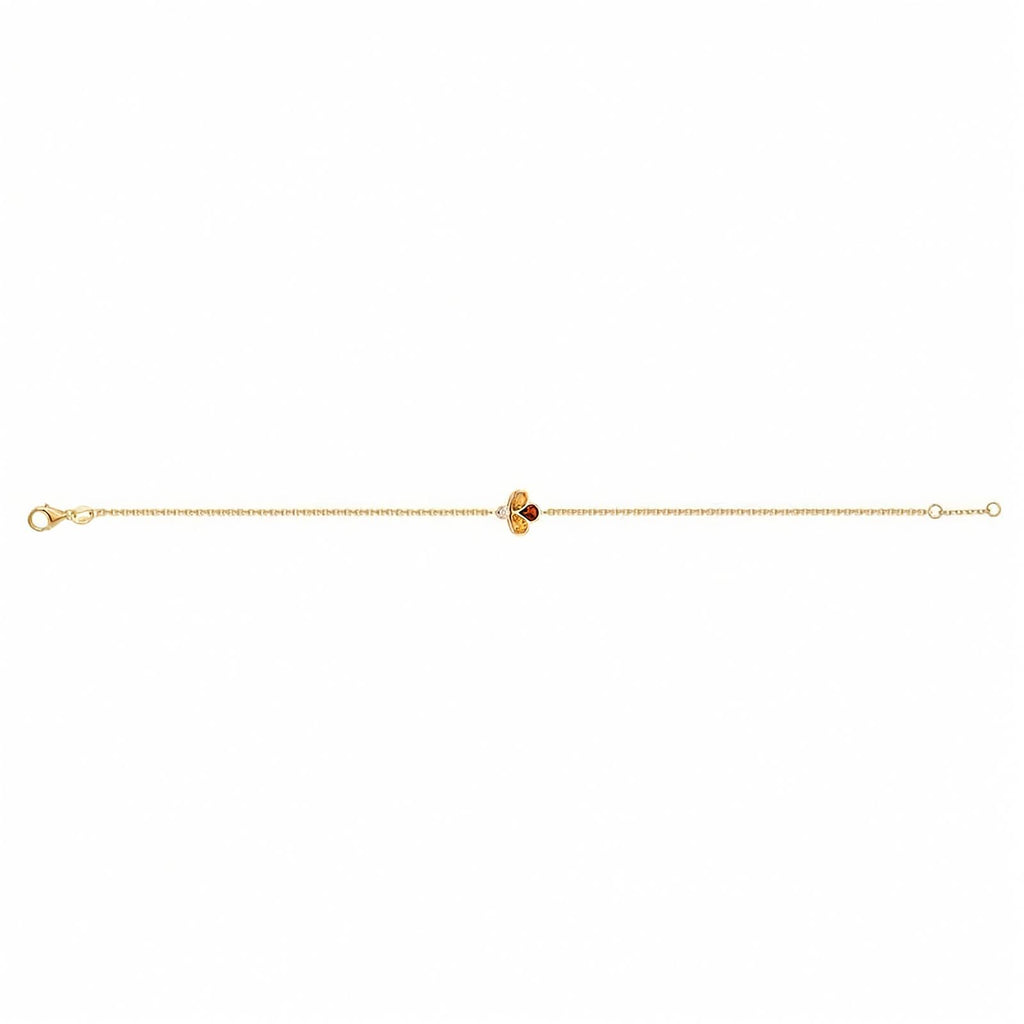 A delicate yellow gold chain bracelet featuring a central clover-like charm with two yellow gemstones, one amber-orange gemstone, and a small clear accent stone, shown on a plain white background.