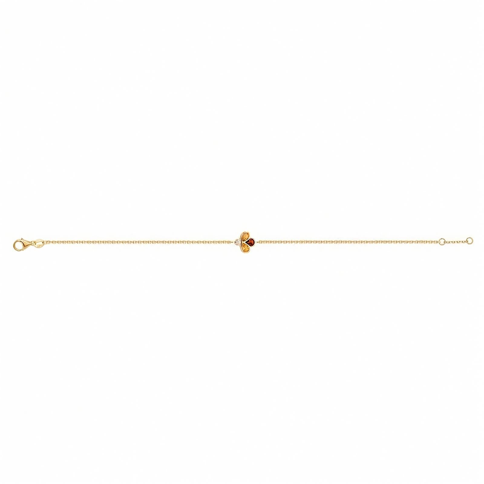 A delicate yellow gold chain bracelet featuring a central clover-like charm with two yellow gemstones, one amber-orange gemstone, and a small clear accent stone, shown on a plain white background.
