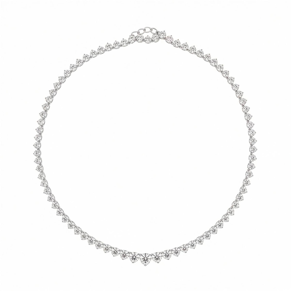 14k white gold 6.00 ctw graduated round lab diamond three-prong tennis necklace. A delicate graduated, three prong  tennis necklace in white gold with small round dimonds, arranged in a circle on a plain white background.