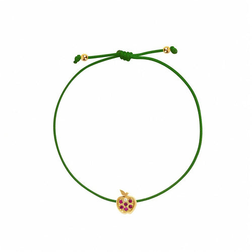 Rosmundo collaboration 18k yellow gold apple string bracelet with natural rubies and diamond on adjustable macrame cord. A green adjustable cord bracelet featuring a small yellow gold apple charm embellished with purple gemstones, set against a plain white background.