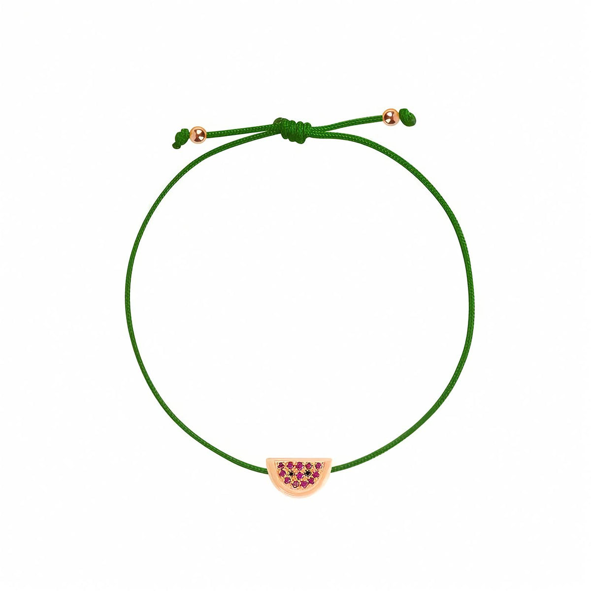 Rosmundo collaboration 18k rose gold watermelon string bracelet with natural rubies and black diamonds on adjustable macrame cord. A green cord bracelet with a watermelon-themed charm featuring pinkish-red seeds and a gold-toned outline, shown on a plain white background.
