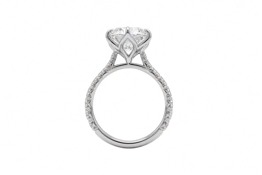 A silver-tone ring featuring a large marquise-cut clear gemstone in a six-prong setting, with a pavé band accented by small round diamonds, shown from the side on a plain white background.