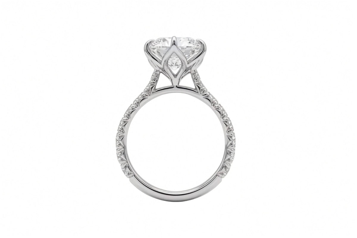 A silver-tone ring featuring a large marquise-cut clear gemstone in a six-prong setting, with a pavé band accented by small round diamonds, shown from the side on a plain white background.