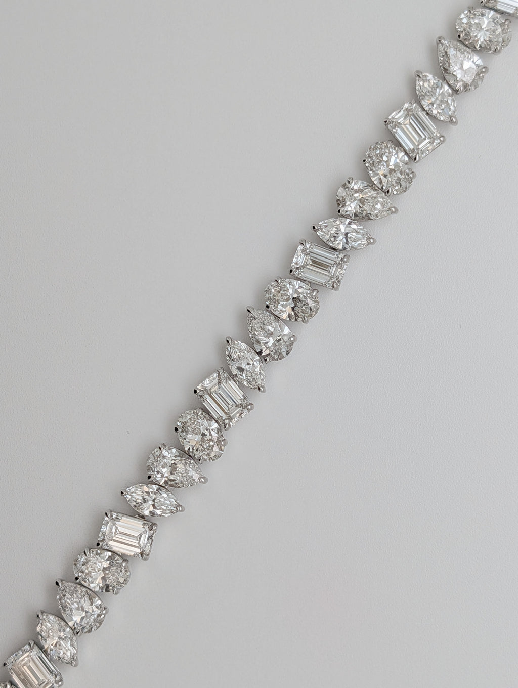 Inga Fine Jewelry 14k White Gold Multi Shape Lab Grown Diamond Bracelet 30.79ctw shown on light gray background laying staright.