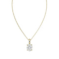 A yellow gold necklace with a single solitaire oval diamond pendant, displayed against a solid white background.