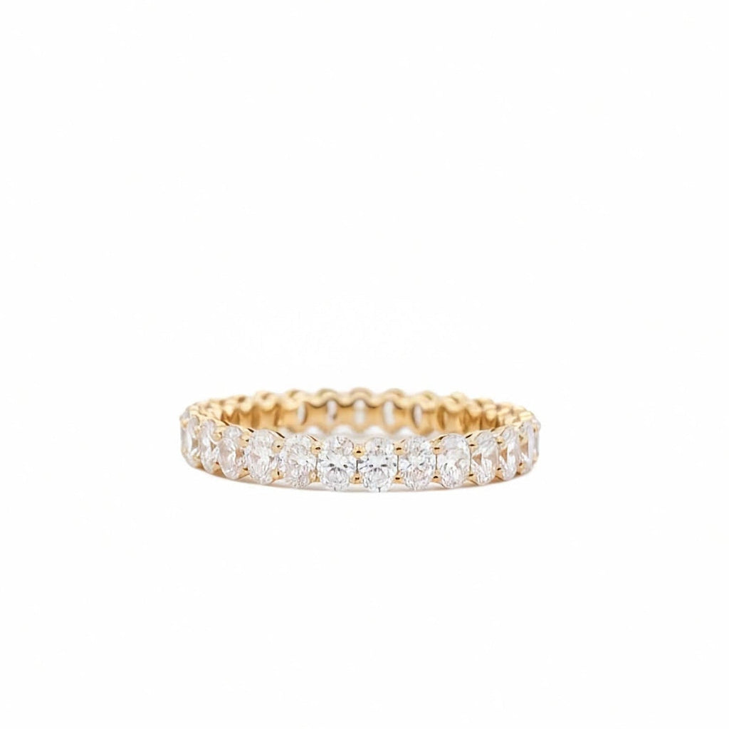 Oval lab grown diamond full eternity band in 14k yellow gold 2.15 ctw on white background on a white background.
