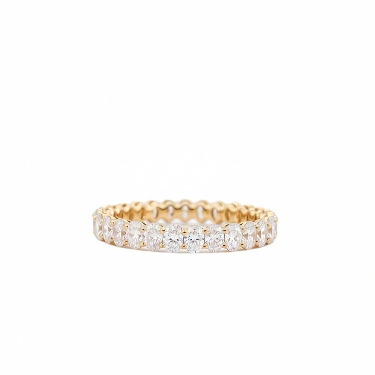 Oval lab grown diamond full eternity band in 14k yellow gold 2.15 ctw on white background on a white background.