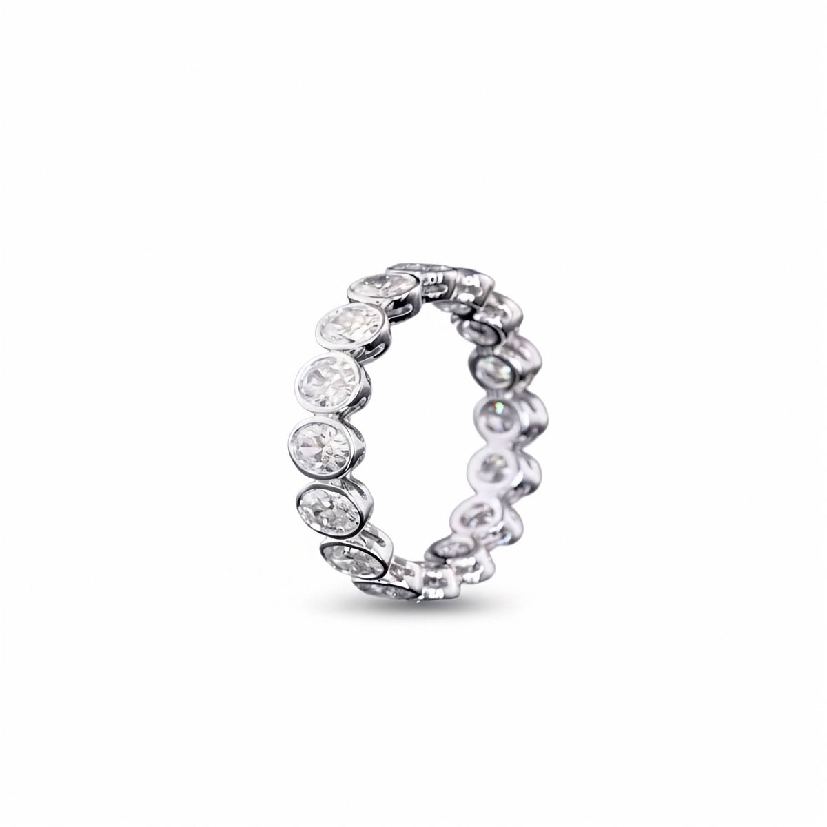 A white gold Oval Diamond Bezel set eternity ring featuring a continuous row of Oval lab grown diamonds, shown on a clean white background.