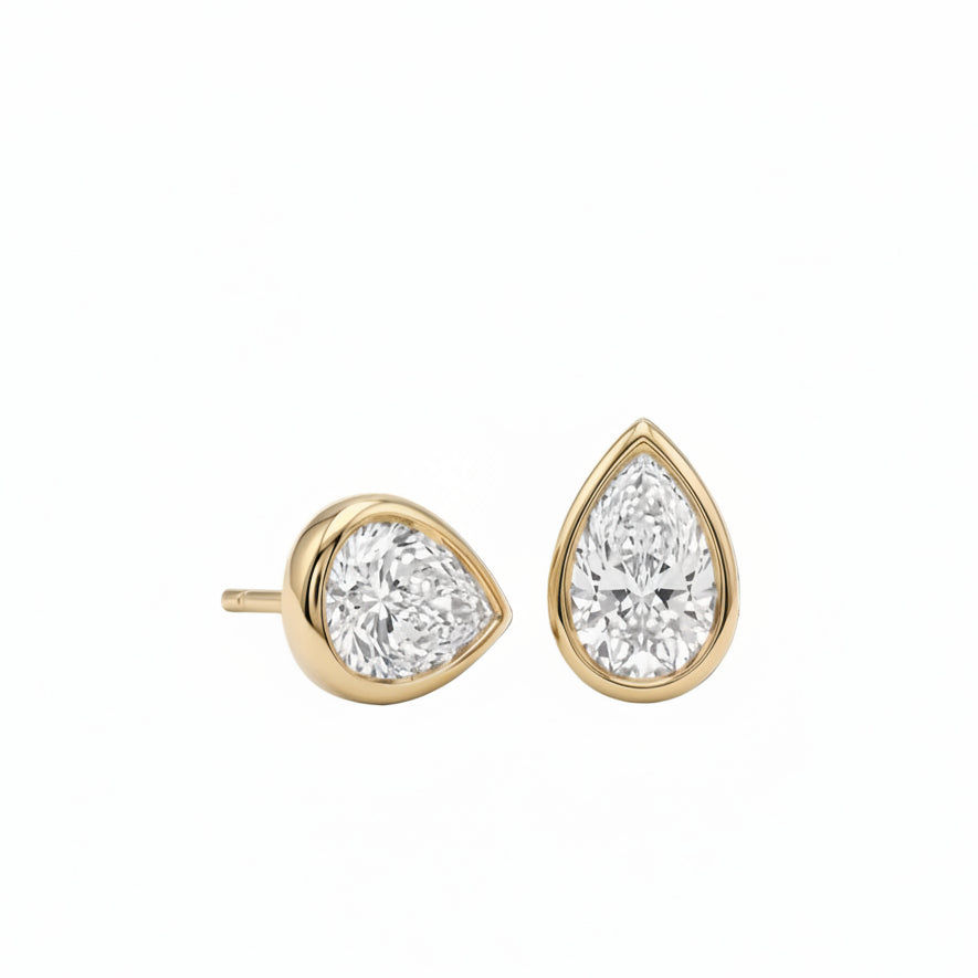 18k yellow gold 3.00 ctw pear-cut lab diamond bezel stud earrings pair. A pair of pear-shaped diamond bezel set stud earrings in yellow gold, shown against a plain white background.
