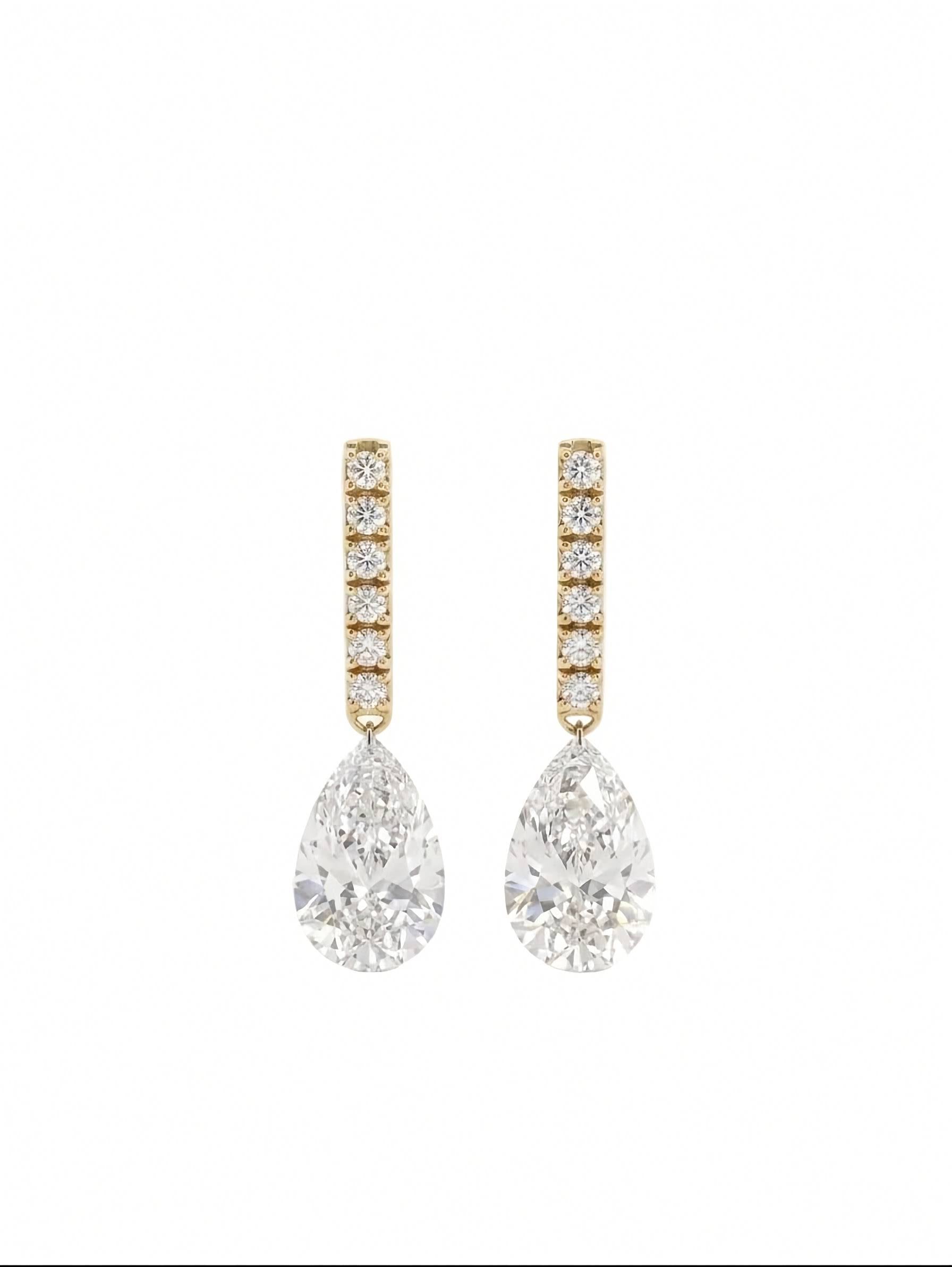 A pair of gold drop earrings featuring a vertical bar of small round-cut diamonds above a large pear-cut diamond drop, set against a clean white background.