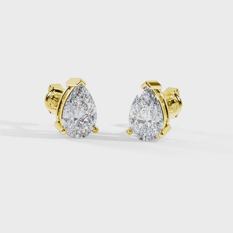 Video of spinning pair of pear-cut diamond stud earrings in yellow gold settings, shown on a plain white background.