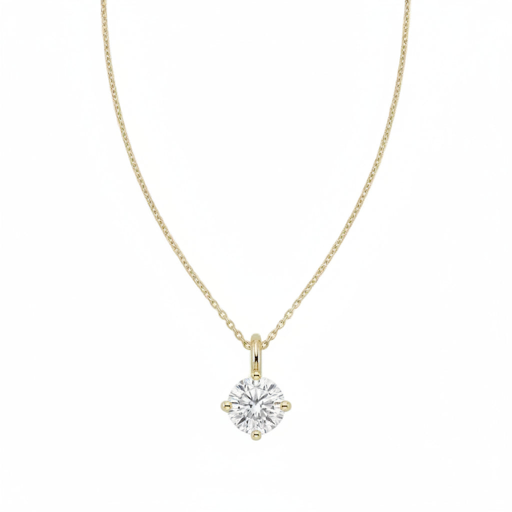 A yellow gold necklace with a single solitaire round diamond pendant, displayed against a solid white background.