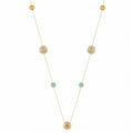 A delicate gold necklace featuring multiple small circular gold ornaments, some with tiny light blue stones and others with textured yellow center stones, displayed on a clean white background.