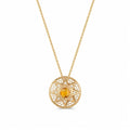 A gold chain necklace with circular pendant  and yellow gemstone accent, shown on a white background.
