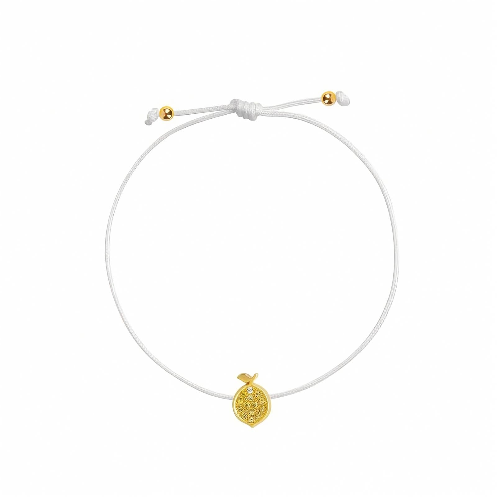 Rosmundo collaboration 18k yellow gold lemon string bracelet with natural yellow sapphires and diamond on adjustable macrame cord. A delicate white cord bracelet featuring a small textured yellow gold lemon charm and adjustable sliding knot with gold accent beads, shown on a plain white background.