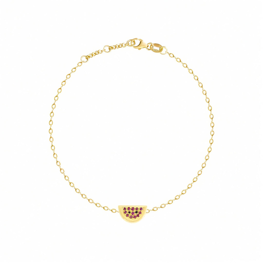 Rosmundo collaboration 18k yellow gold watermelon chain bracelet set with natural rubies and black diamonds. A delicate yellow gold chain bracelet with a small watermelon charm adorned with dark red gemstones, displayed on a clean white background.