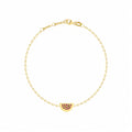 Rosmundo collaboration 18k yellow gold watermelon chain bracelet set with natural rubies and black diamonds. A delicate yellow gold chain bracelet with a small watermelon charm adorned with dark red gemstones, displayed on a clean white background.